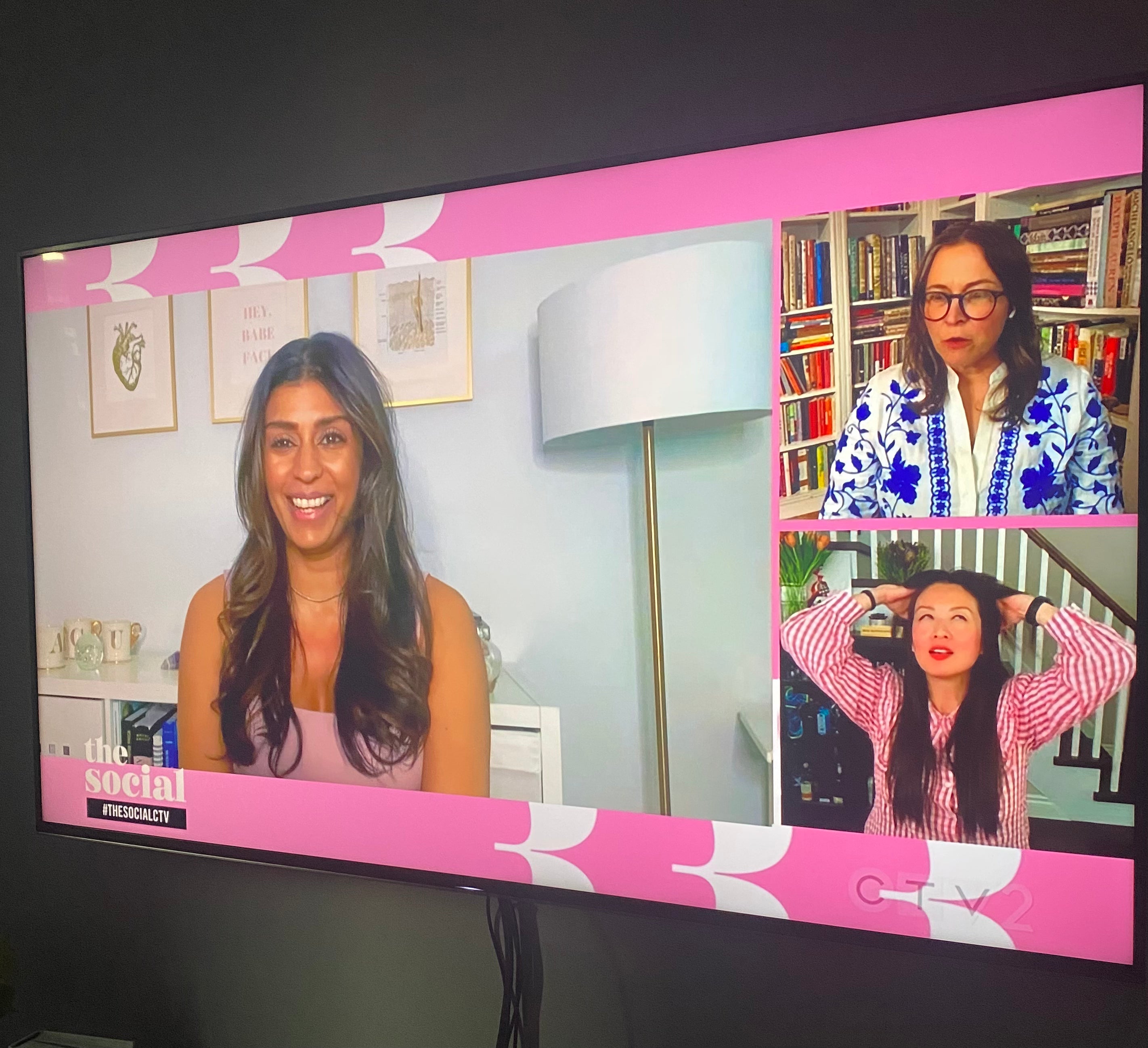 TV screen showing a video call with three women on a pink-themed interface.