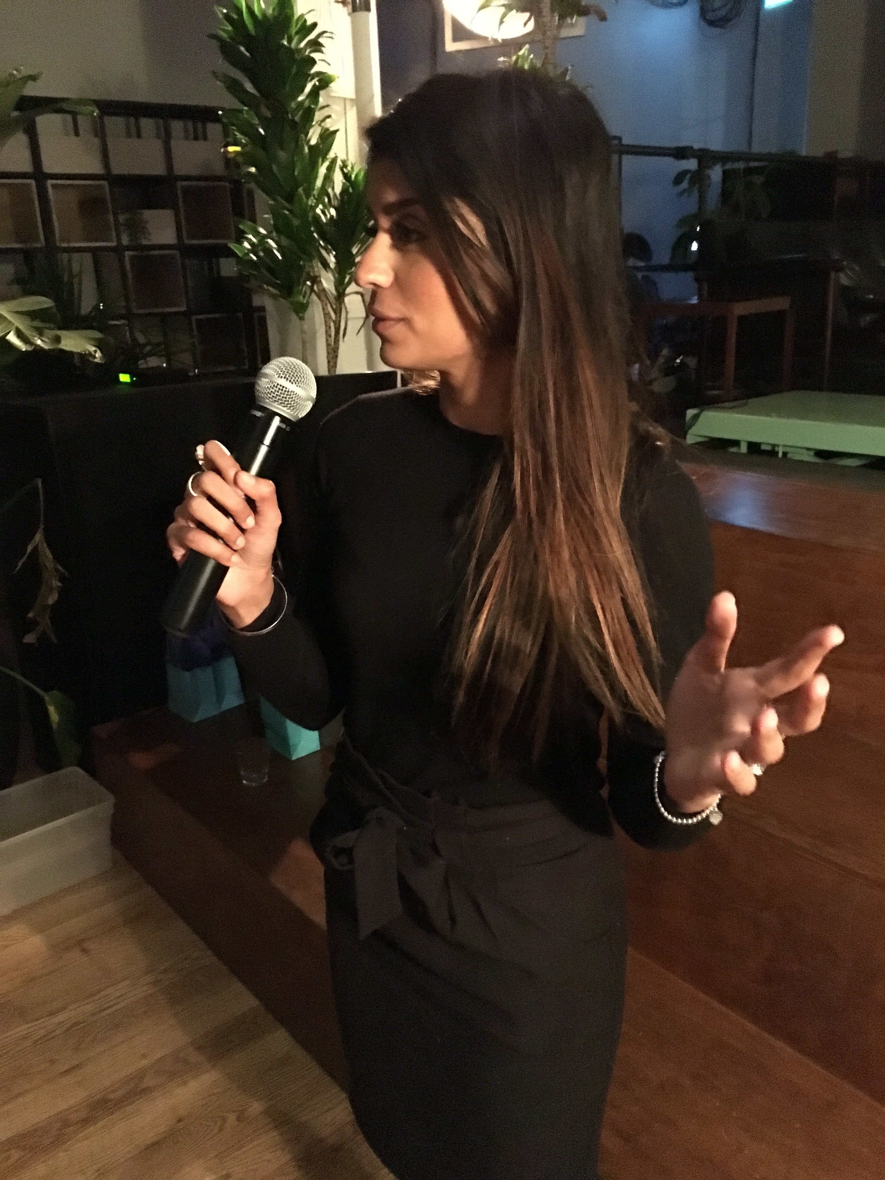 Auracle founder Amrit Singh speaking into microphone at Toronto event