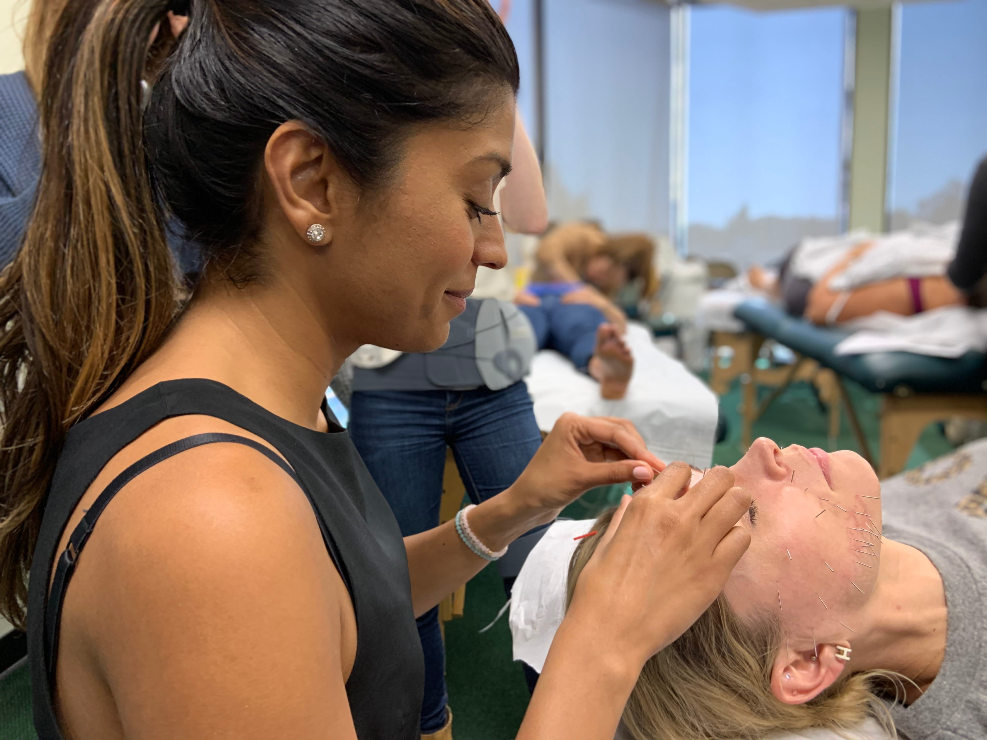 Amrit Singh learning cosmetic techniques during acupuncture training