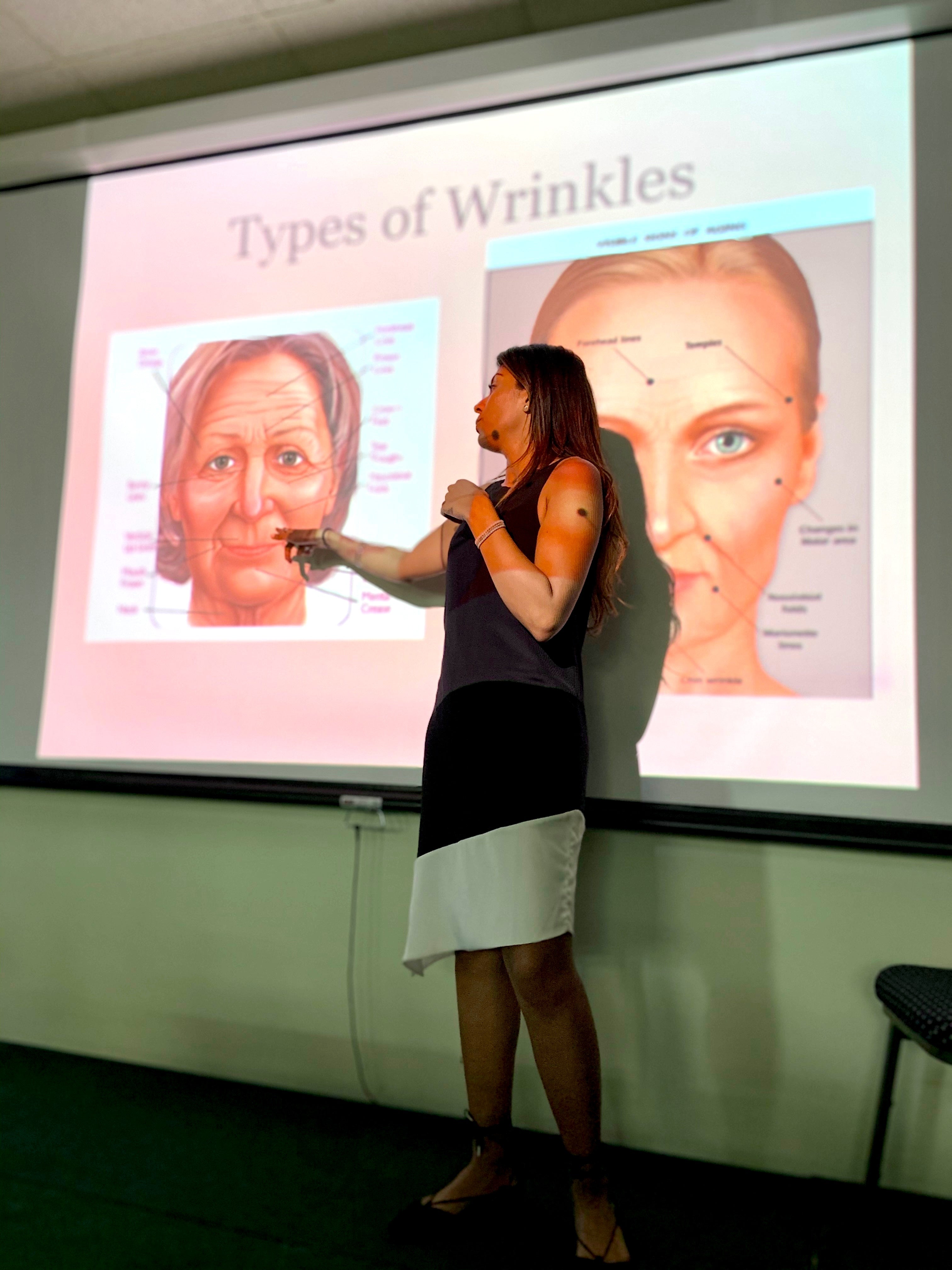 Amrit Singh pointing at a presentation slide about types of wrinkles on a screen.